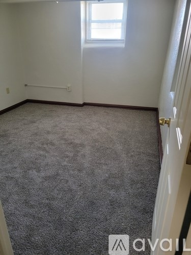 A room with a carpeted floor and a window.