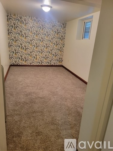 A room with a carpeted floor and a patterned wallpaper.