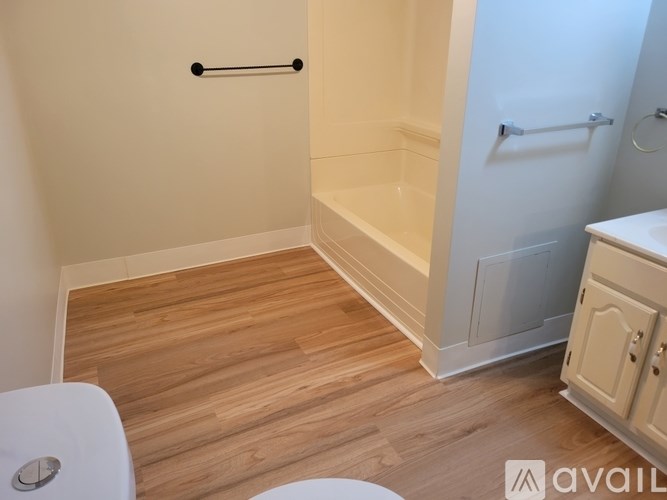 A bathroom with a toilet, a bathtub, and a cabinet.