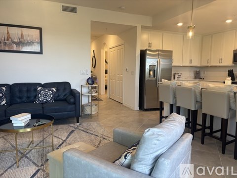 A living room with a black couch and a grey armchair.