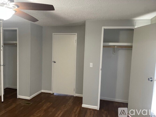 A room with a ceiling fan and a door.