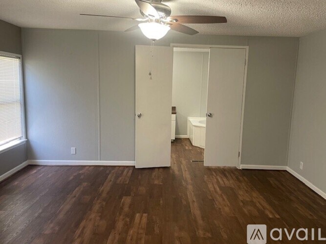 A room with wood flooring and a ceiling fan.