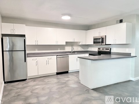 A modern kitchen with white cabinets and stainless steel appliances.