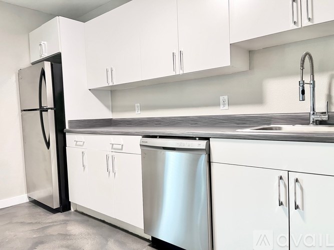 A modern kitchen with white cabinets and stainless steel appliances.