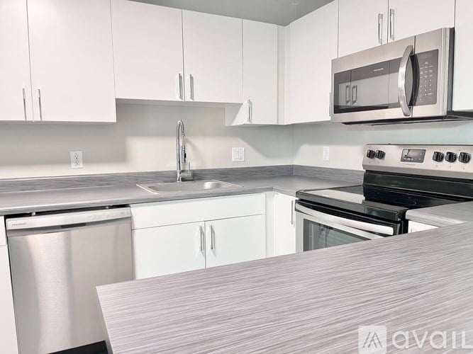 A kitchen with white cabinets and a stainless steel dishwasher.