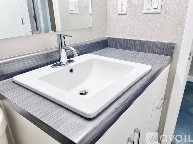 A white sink with a silver faucet is on a countertop.