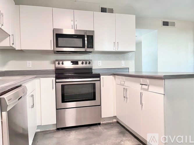 A kitchen with white cabinets and stainless steel appliances.