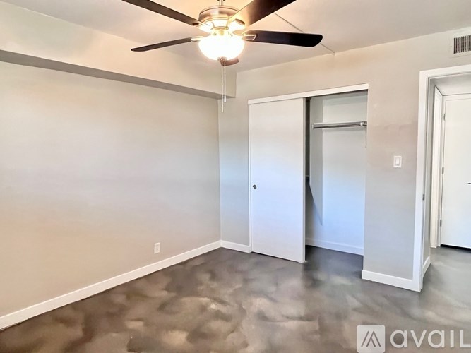 A room with a ceiling fan and a door.