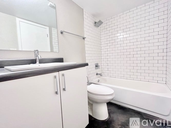 A white toilet sits next to a white bathtub in a bathroom.