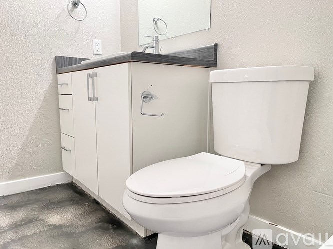 A white toilet sits next to a white sink in a bathroom.