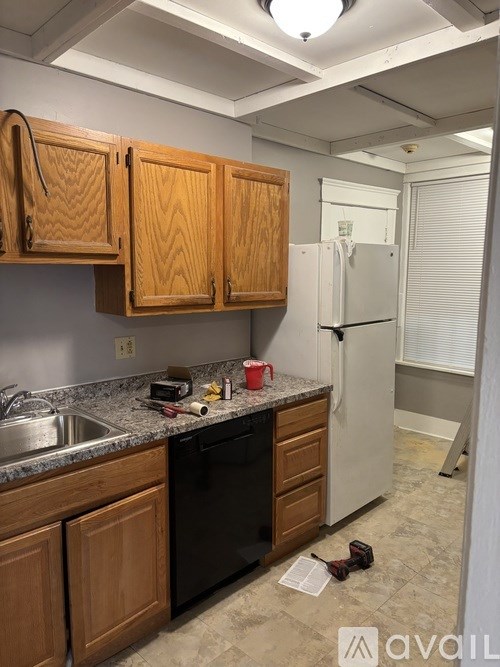 A kitchen with wooden cabinets and a white refrigerator.