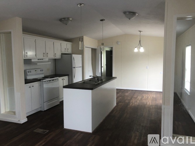 A kitchen with white cabinets and a black countertop.