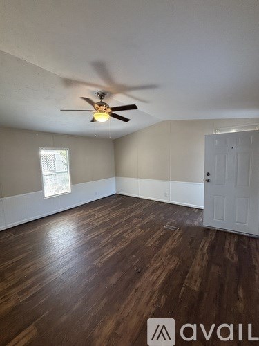 A kitchen with white cabinets and a black countertop is available for rent.