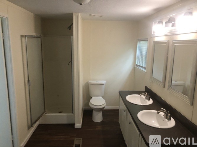 A bathroom with a toilet, sink, and shower.