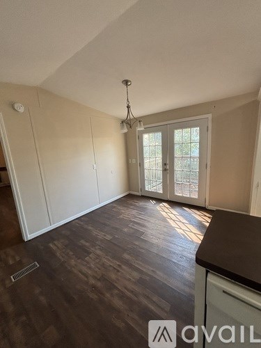 A room with wooden flooring and a chandelier.