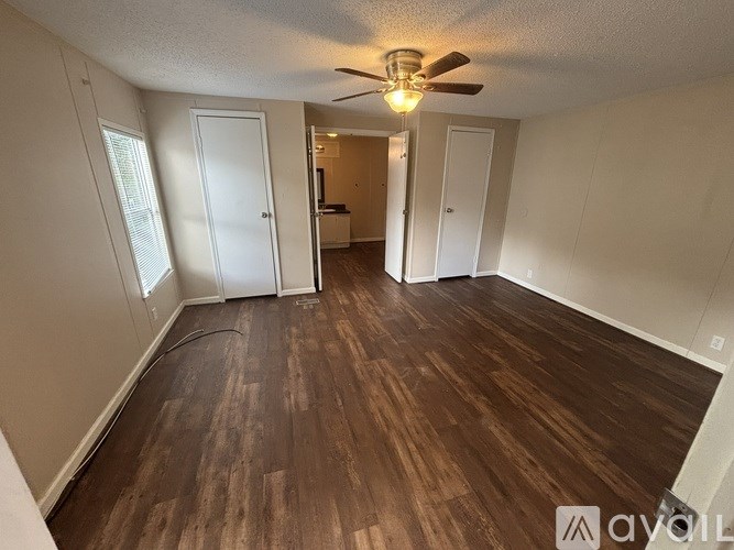 A room with wooden flooring and a ceiling fan.