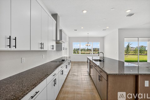 A modern kitchen with white cabinets and a large island.