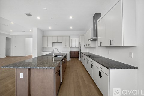A modern kitchen with white cabinets and a marble countertop.