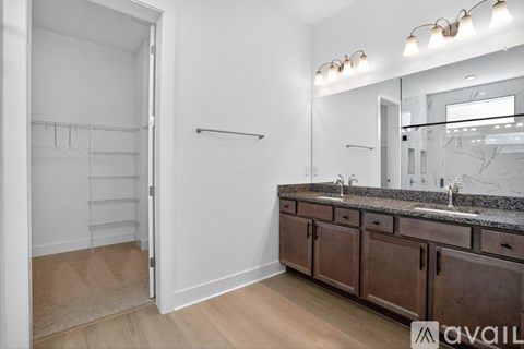 A bathroom with a white door, a mirror, and a sink.
