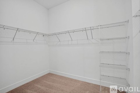 Empty room with wire shelving and carpeted floor.