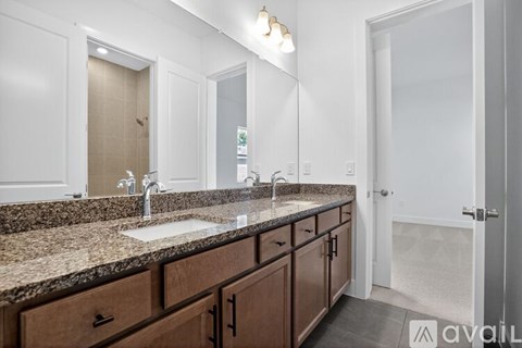 A bathroom with a granite countertop and a double sink vanity.