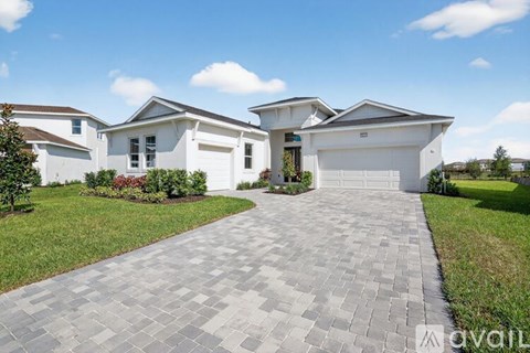 A large white house with a driveway in front.