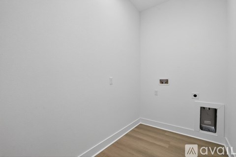 A room with a white wall and a wooden floor.