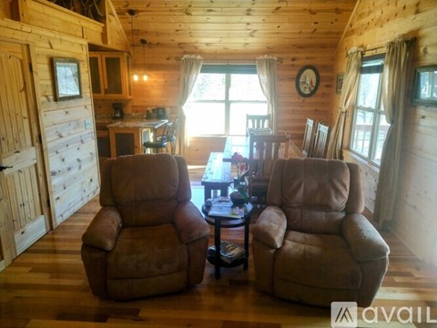 Two brown recliner chairs are in a living room with wood floors and a wooden ceiling.