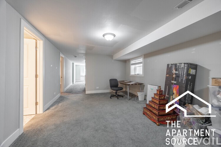 A spacious apartment with a carpeted floor and white walls.