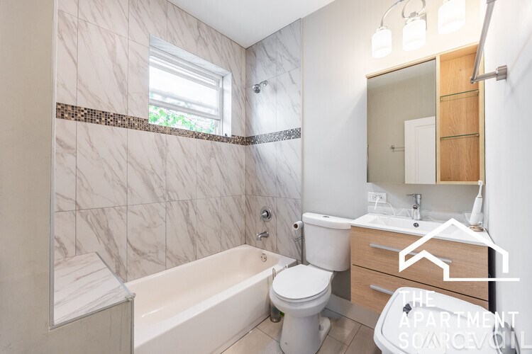 A bathroom with a tub, toilet, and sink.