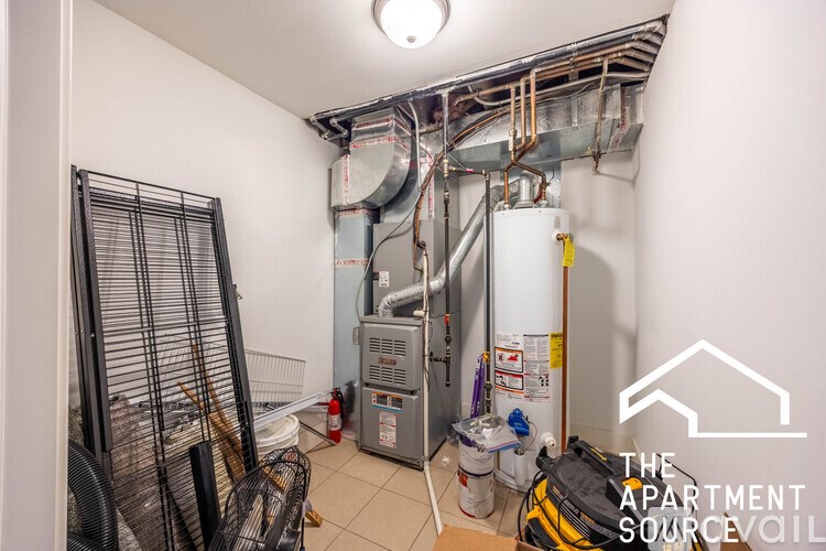 A room with a furnace and a wall-mounted air conditioner unit.