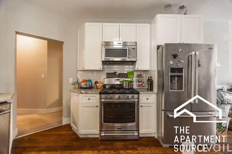 A kitchen with white cabinets and stainless steel appliances.