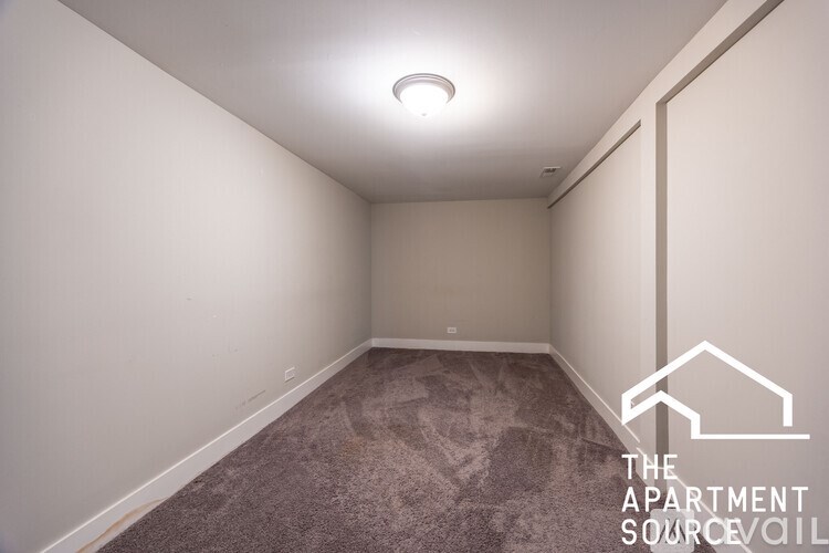 A room with a carpeted floor and a light on the ceiling.
