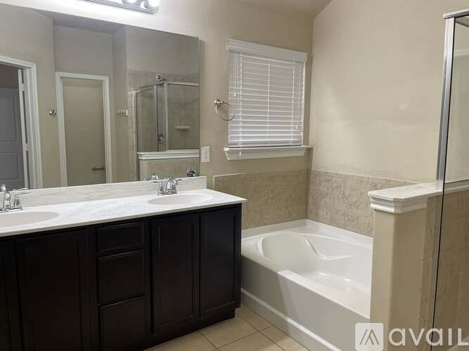 A bathroom with a white sink, a bathtub, and a mirror.