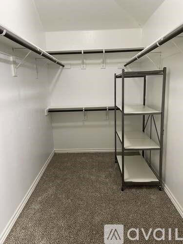 A storage room with shelving units and a carpeted floor.