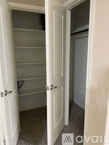 A white door is open to a small, empty room.