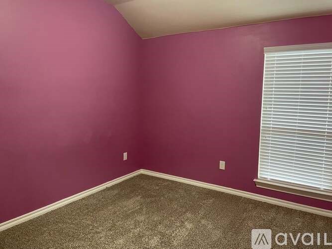 A room with a window and carpeted floor.