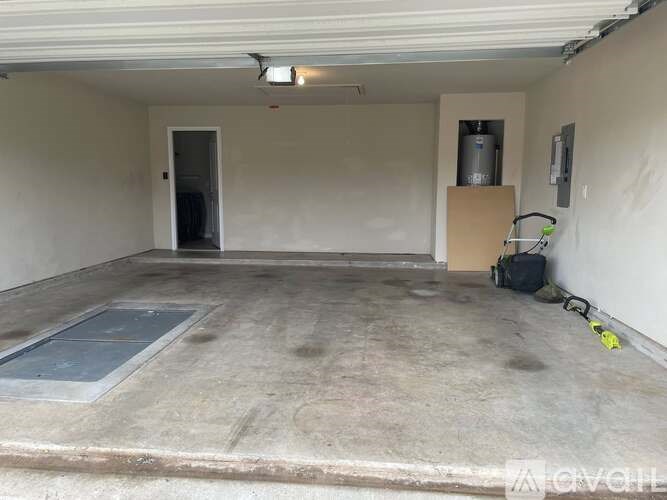 A spacious garage with a concrete floor and a door leading to another room.