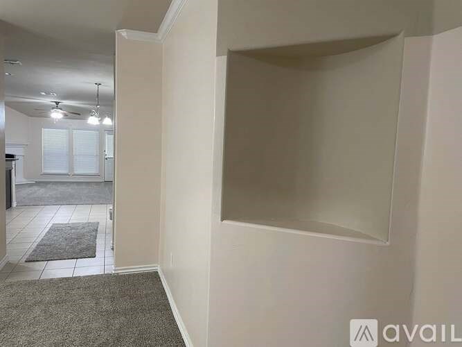 A room with a carpeted floor and a wall with a mirror.