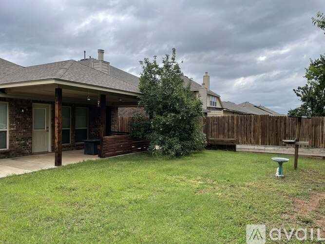 A house with a brown roof and a green lawn.