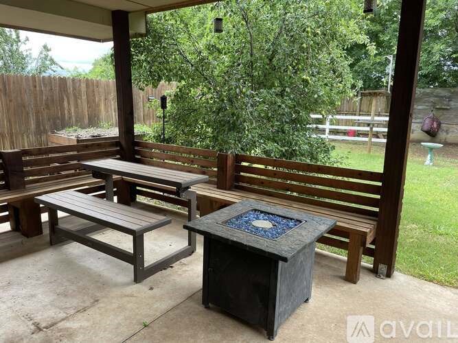 A wooden bench with a square table in front of it.