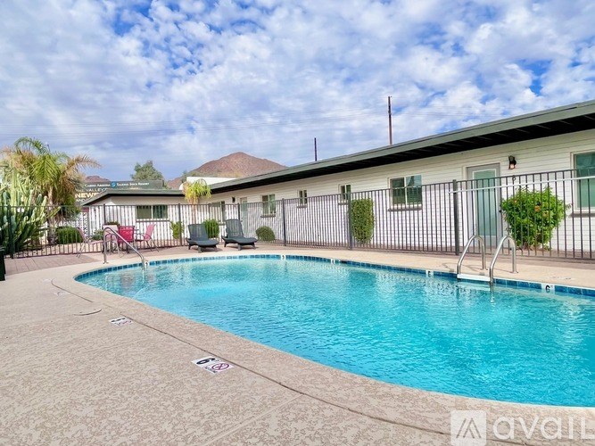A pool with a slide and a building behind it.