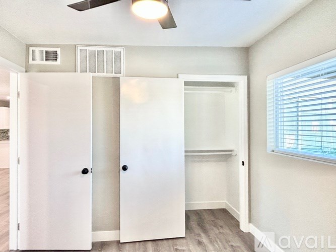 A room with a white door and a window with blinds.