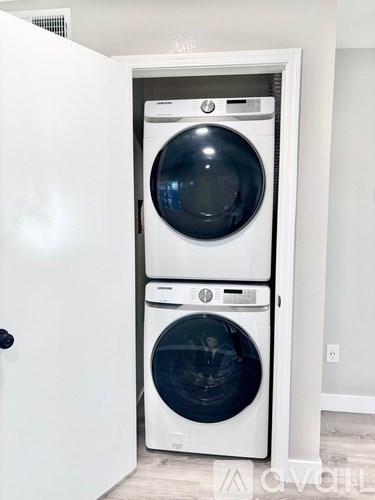 A white washing machine and dryer in a cabinet.