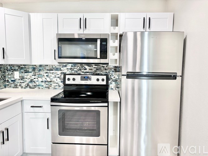 A kitchen with a stove, oven, microwave, and refrigerator.