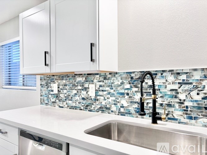 A kitchen with a sink and a washing machine.