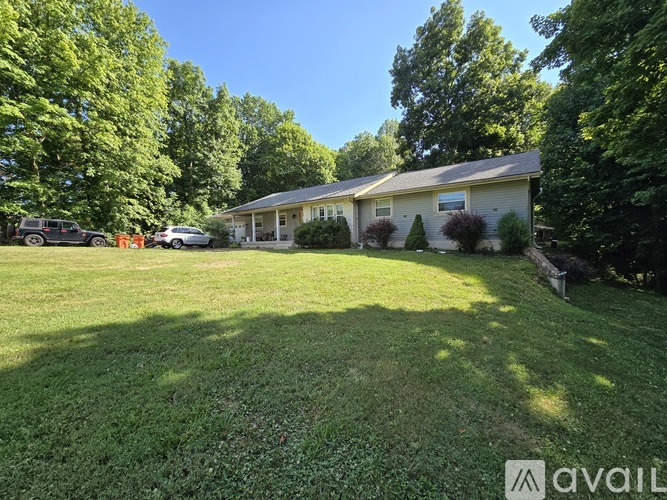 A house with a well-maintained lawn and trees in the background.