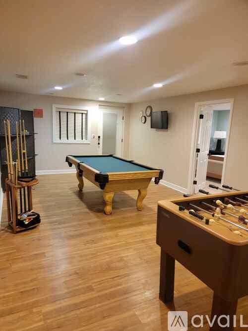 A room with a pool table and a foosball table.