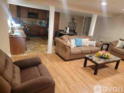 A living room with brown furniture and a wooden floor.