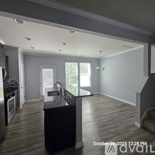 A kitchen with a black countertop and stainless steel appliances.